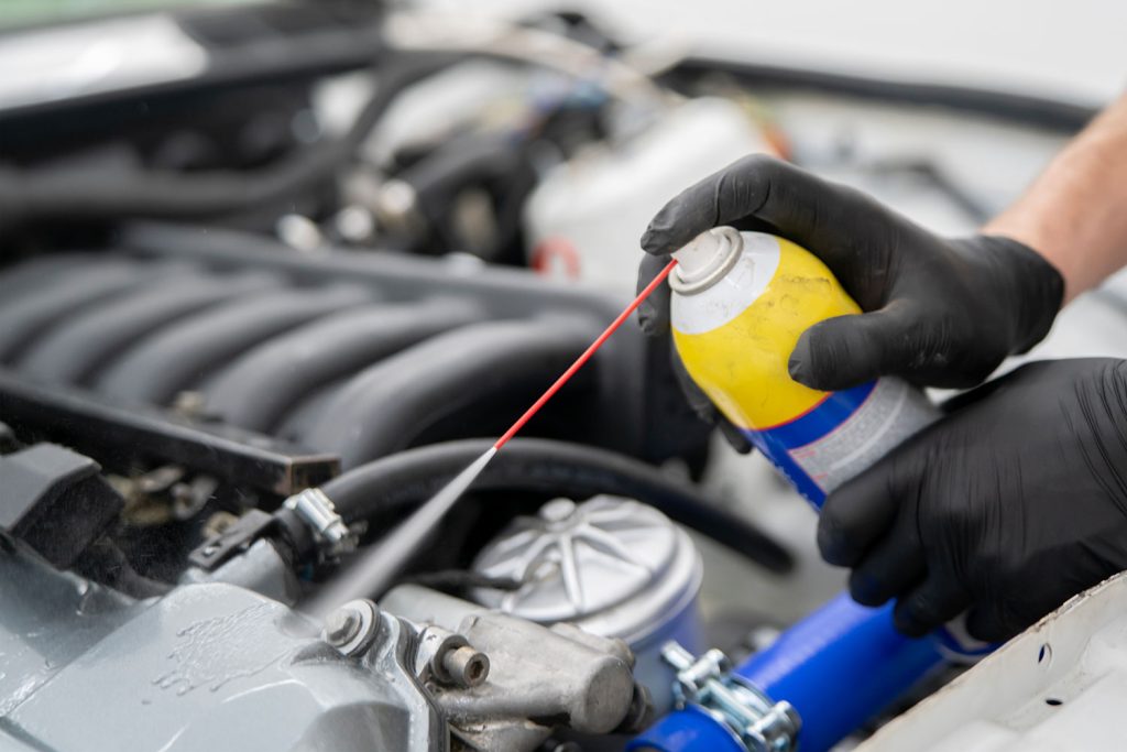 Using a car cleaner spray a person applies